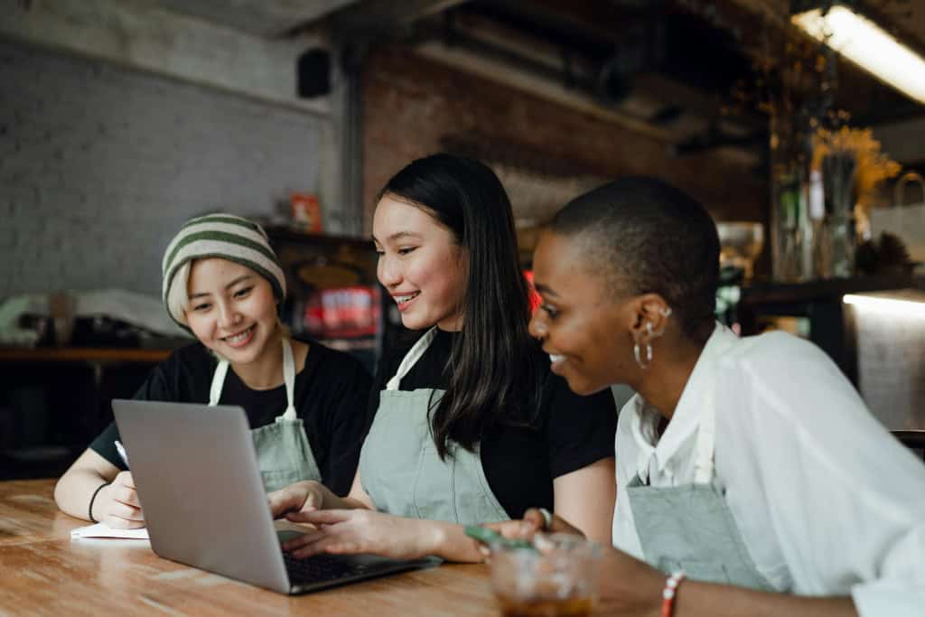 Three women enjoying working on laptop.