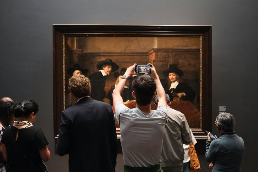 A man taking photo of a piece of art.