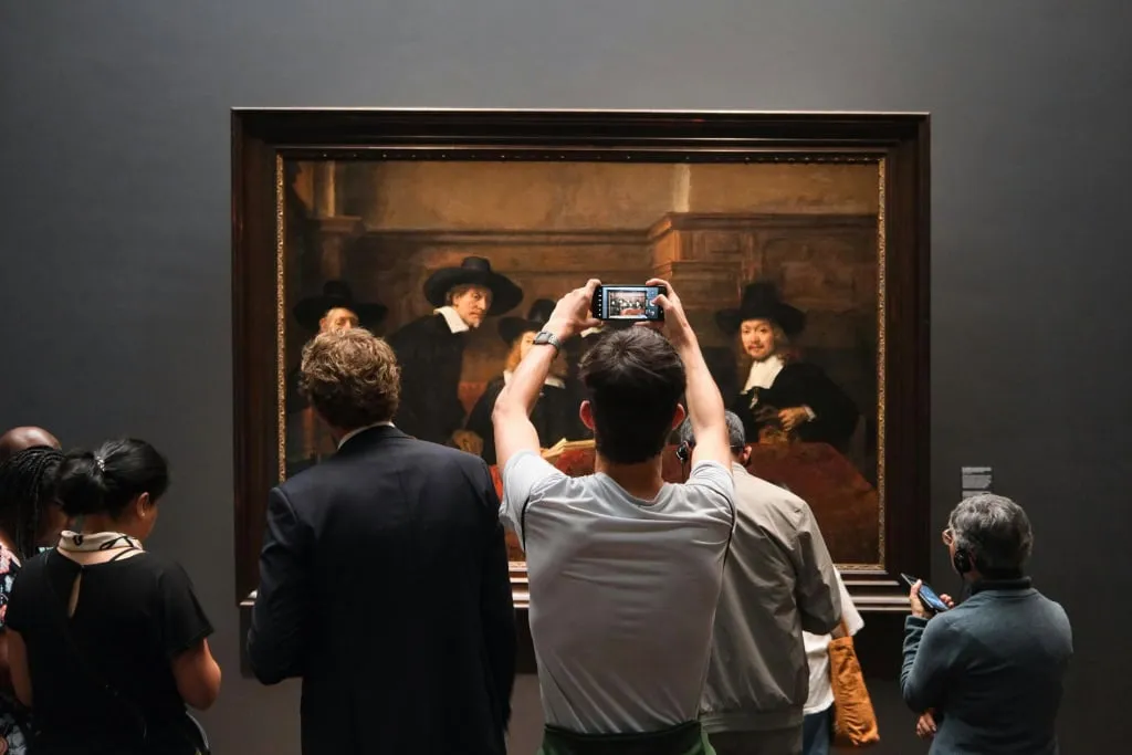 A man taking photo of a piece of art.