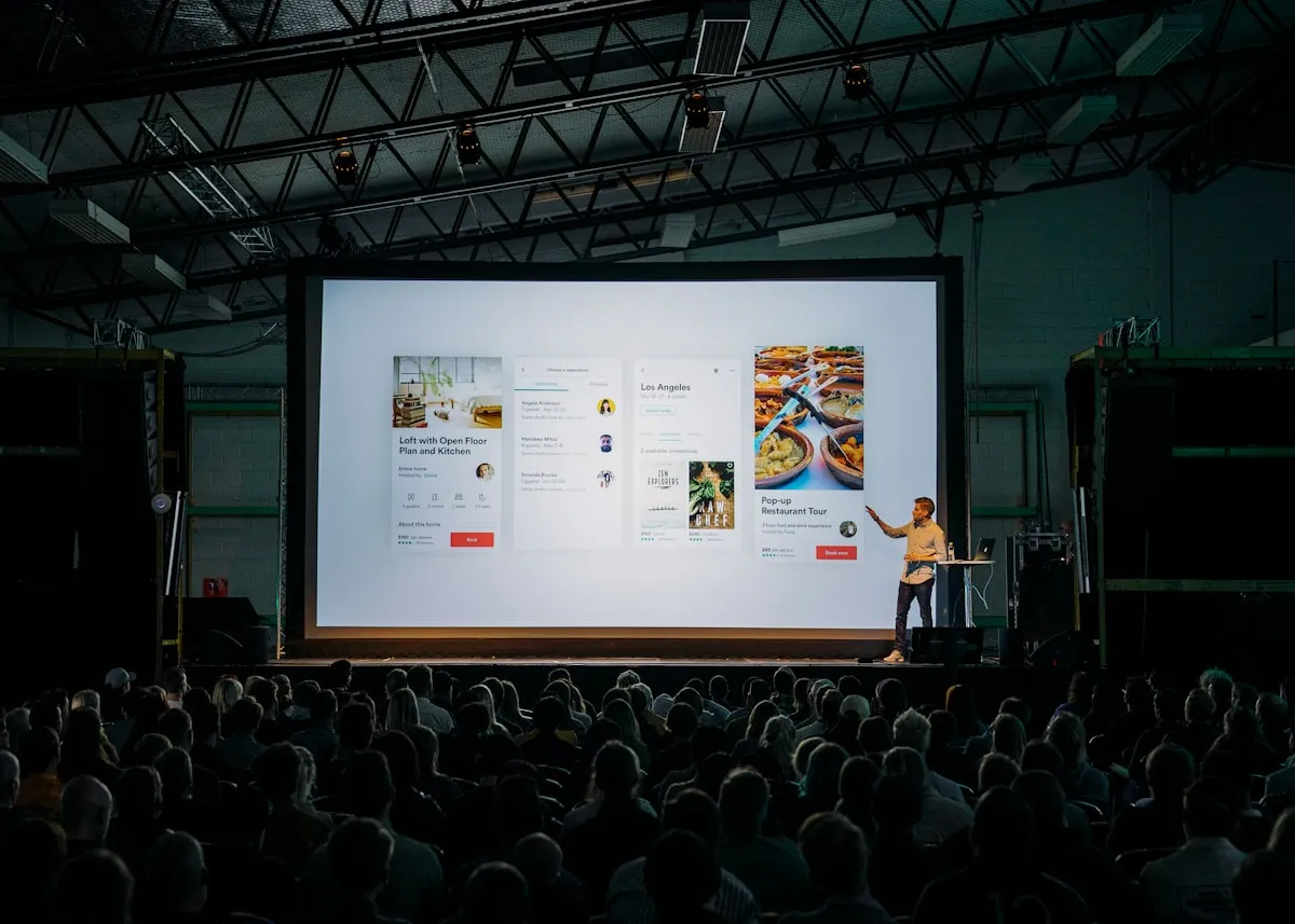 Presenter speaking to a large audience at a corporate town hall event