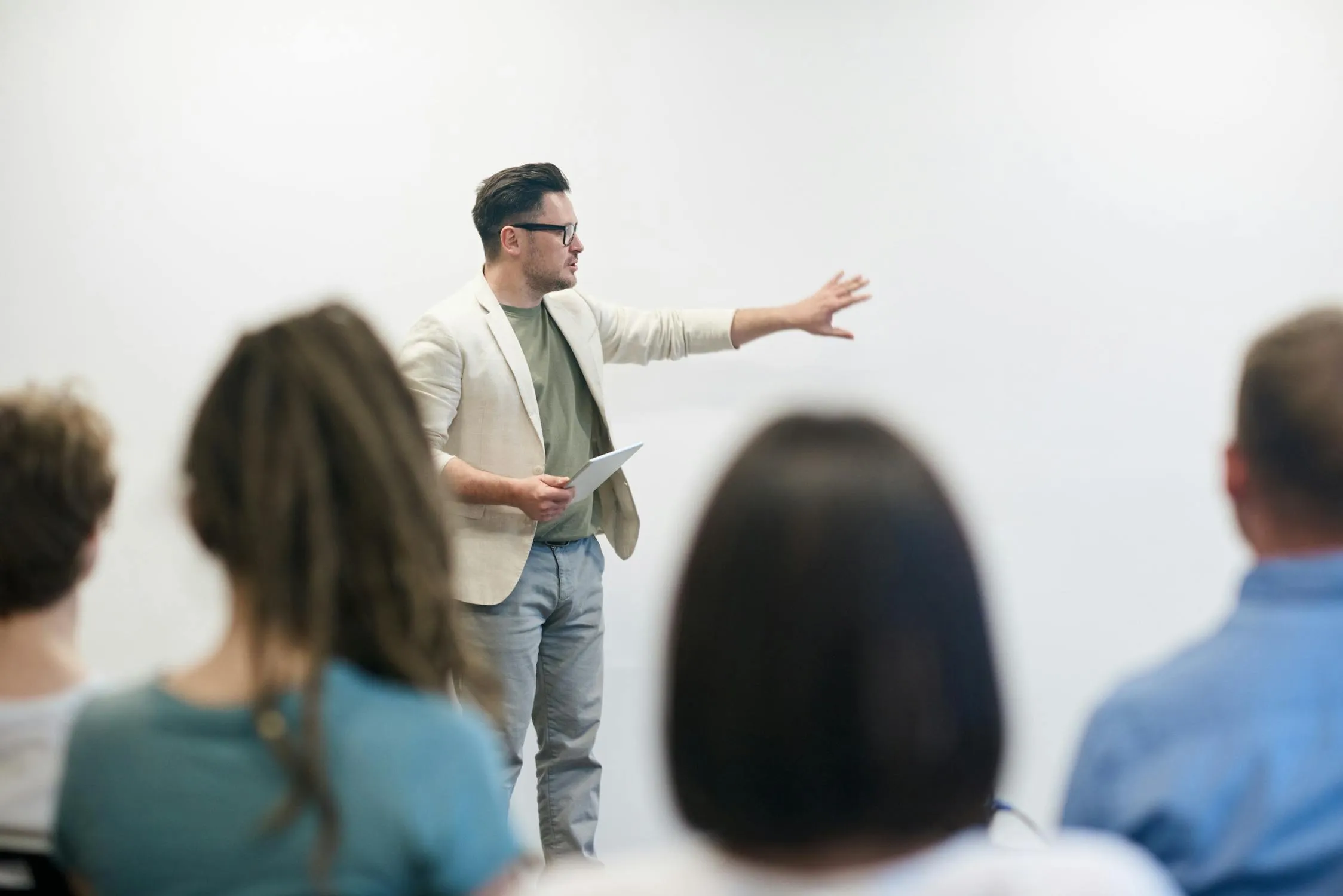 Speaker presenting confidently to an audience using expressive hand gestures and open body language