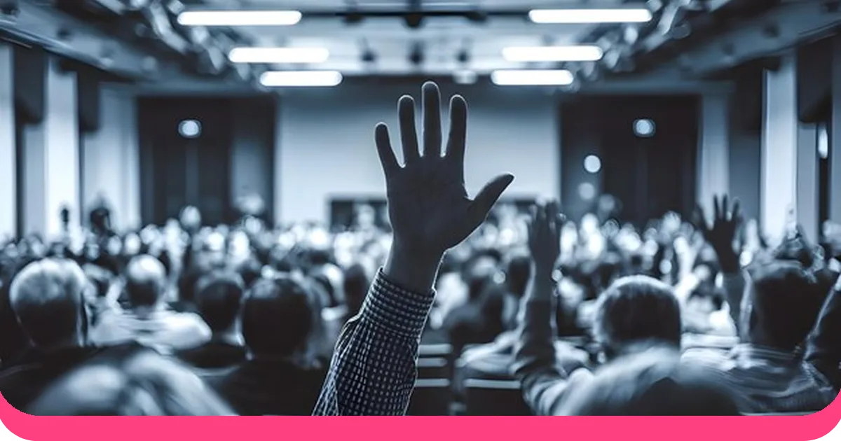 Engaged audience raising hands during a presentation