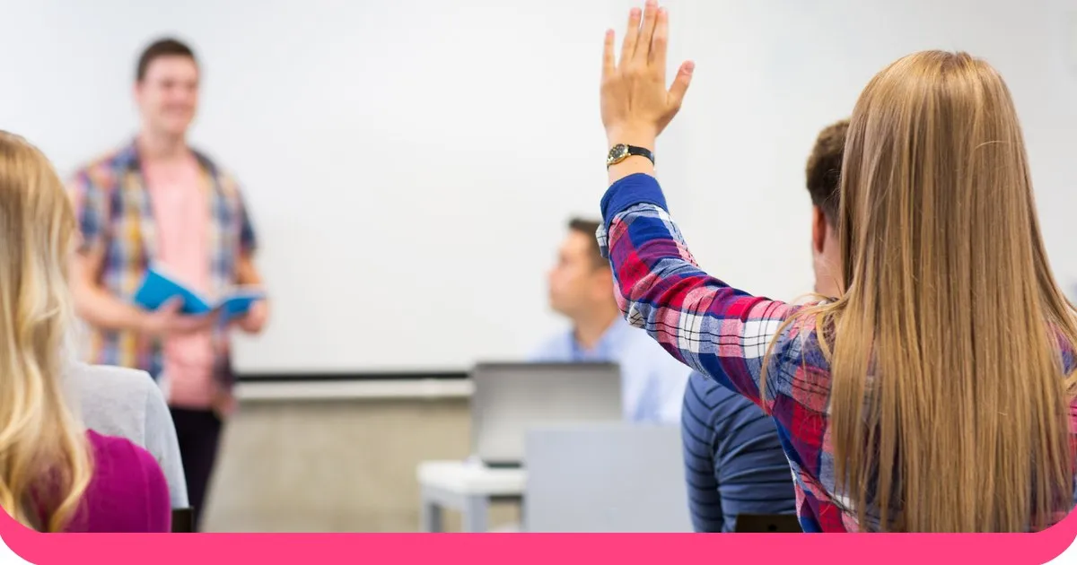 Group of students raising hands in a lecture hall